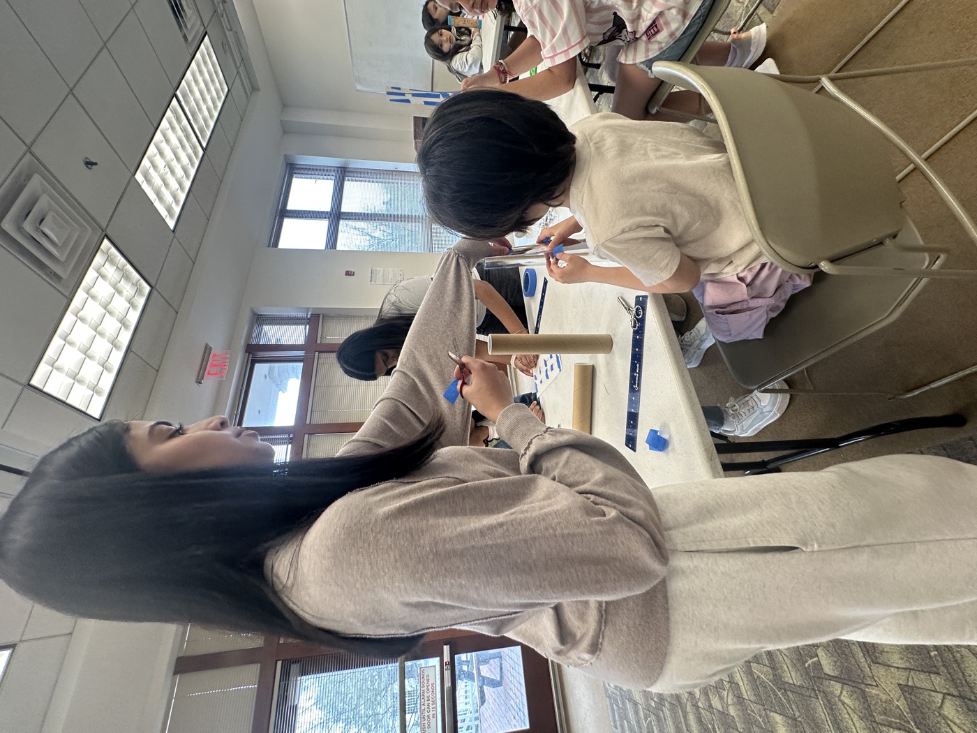 A student volunteer helping a young participant with a workshop activity